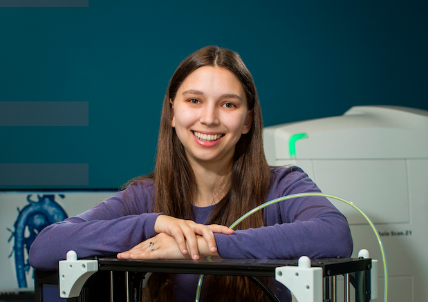 Portrait photo of Dr. Sara McArdle with a piece of imaging equipment