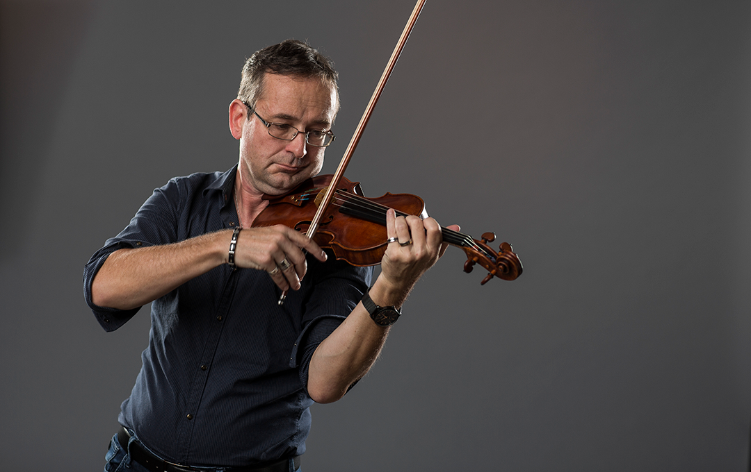 Portrait photo of Matthias von Herrath playing the violin