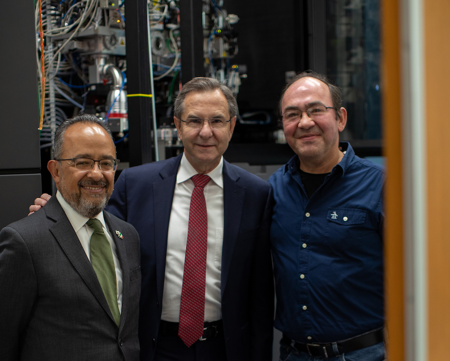 Three men stand in front of machinery at LJI