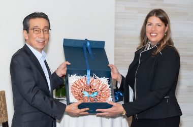 Photo of LJI and Kyowa Kirin leadership with a large coral piece to commemorate the research partnership anniversary.