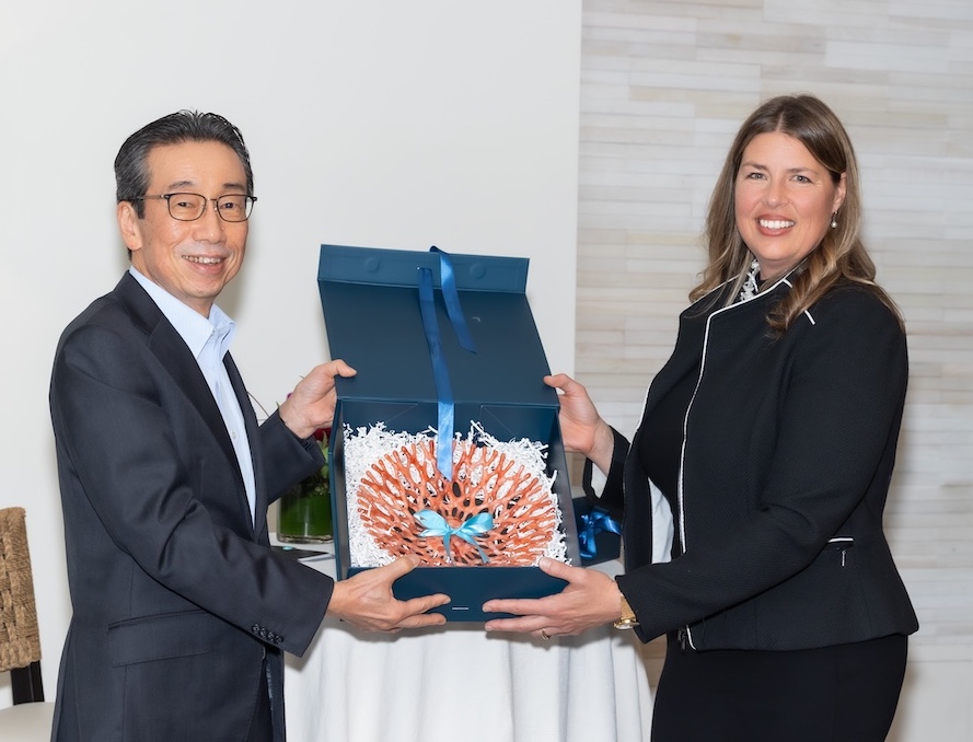 Photo of LJI and Kyowa Kirin leadership with a large coral piece to commemorate the research partnership anniversary.