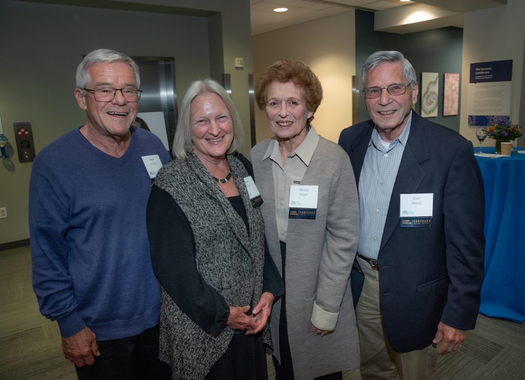 Posed photo of four LJI supporters smiling at the camera in the LJI Atrium