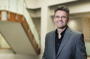 Portrait photo of Dr. Croft. He stands in the Institute and smiles at the camera.