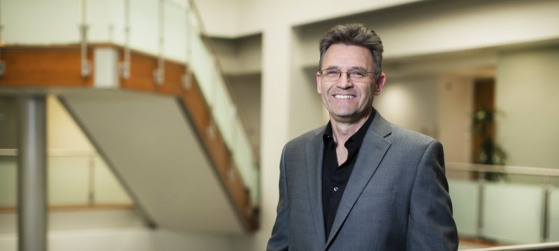 Portrait photo of Dr. Croft. He stands in the Institute and smiles at the camera.